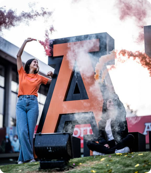 Estudiante Anáhuac celebrando frente a la letra A
